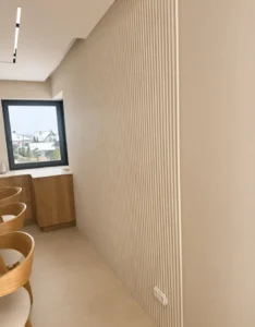 ściana wykończona lamelami, sufit podwieszany i duże płytki na podłodze wykończenie zrealizowane przez Atłas Design
